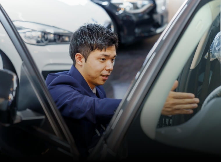 車の中を丁寧に確認する査定士