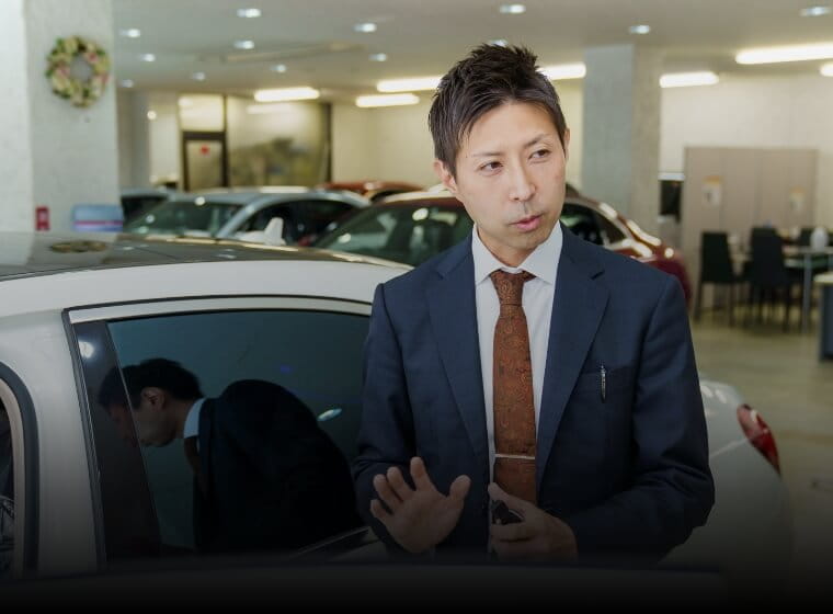 スーツ姿の営業マンが顧客と商談している様子